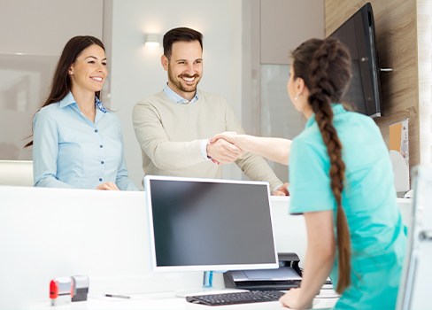 Smiling man and woman at reception desk