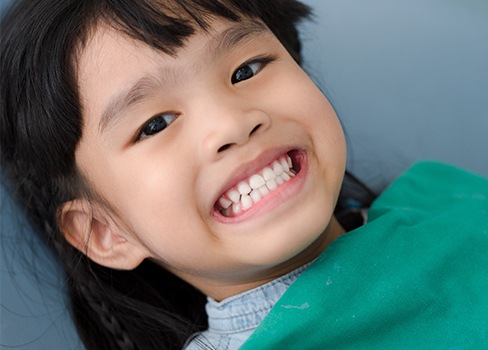 Child in dental chair smiling