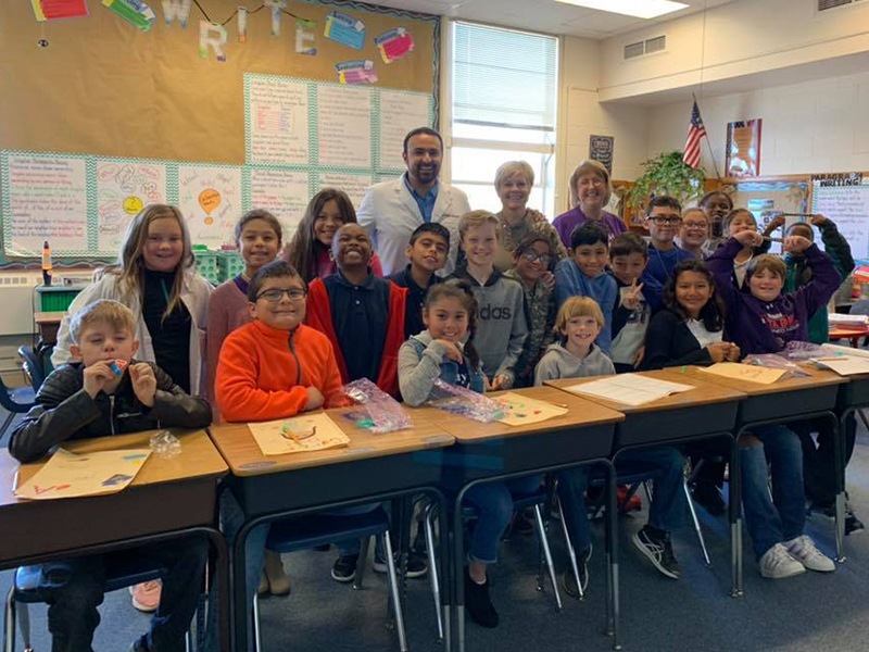 Dentist and team members in school classroom