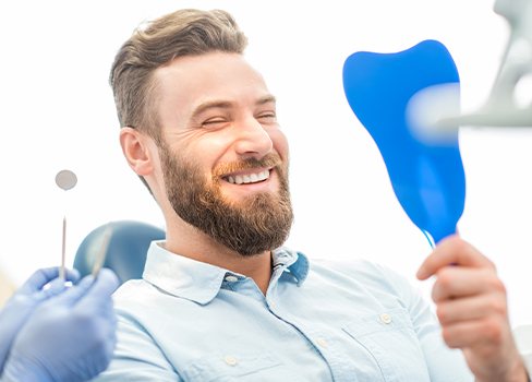 Man looking at smile in mirror