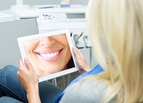 Woman looking at smile design on tablet computer