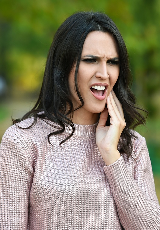 Woman in pain holding jaw
