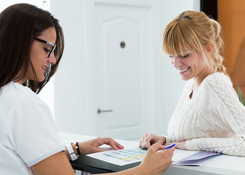 Woman talking to team member at reception desk