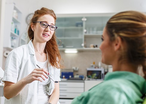 Team member talking to patient in dental chair