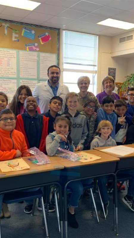 Dentist and team members in classroom