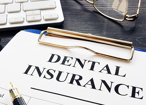 Dental insurance forms on clipboard
