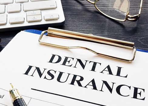 Dental insurance forms on clipboard