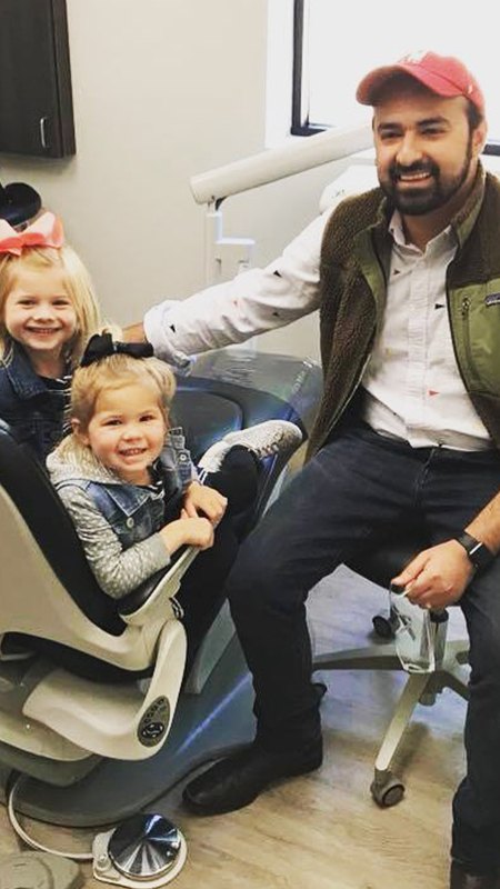 Dr. Kazmi and two young patients in dental exam room