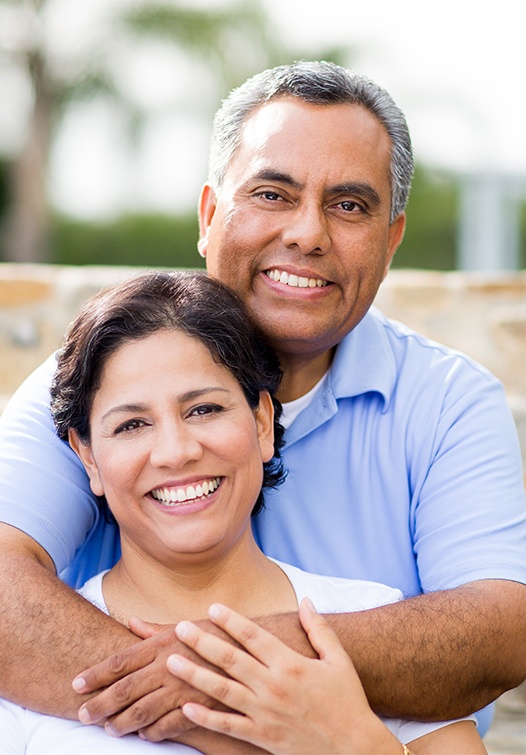 Older man and woman smiling outdoors