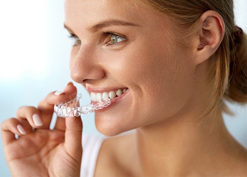 Woman placing Invisalign tray