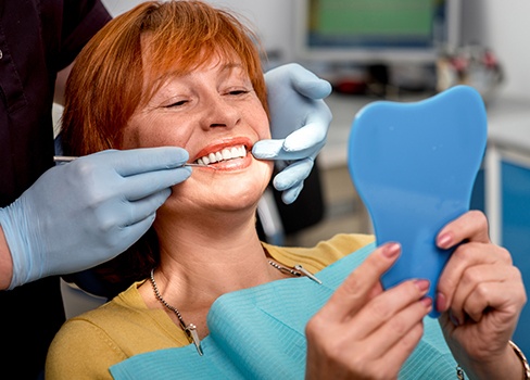 Woman looking at smile in mirror