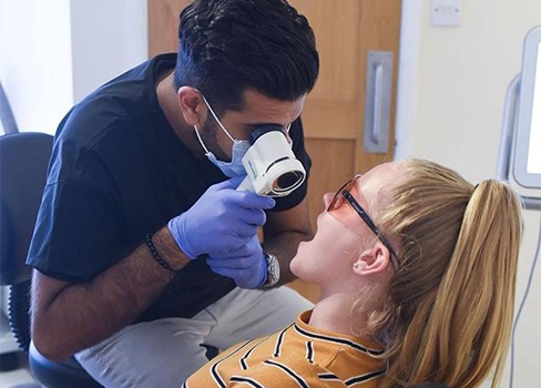 Dentist performing oral cancer screening