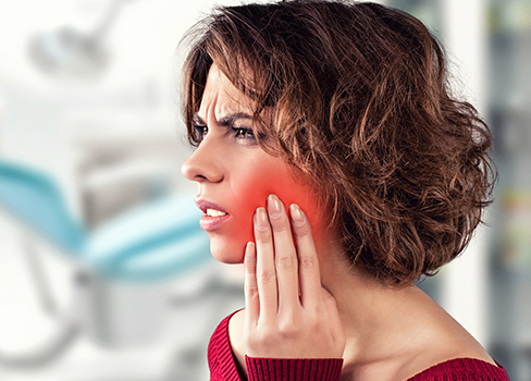 Woman holding cheek in pain